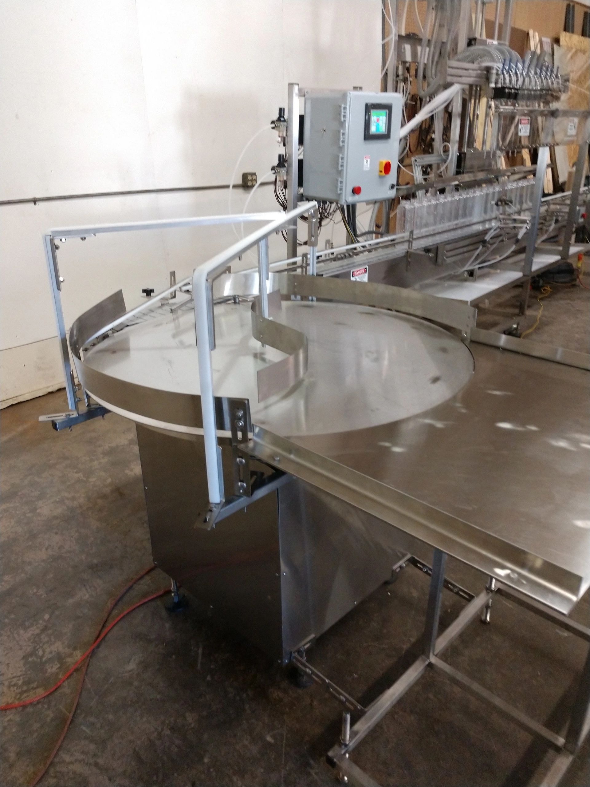 Feed turntable loading bottles onto the filler conveyor and into the liquid filling machine