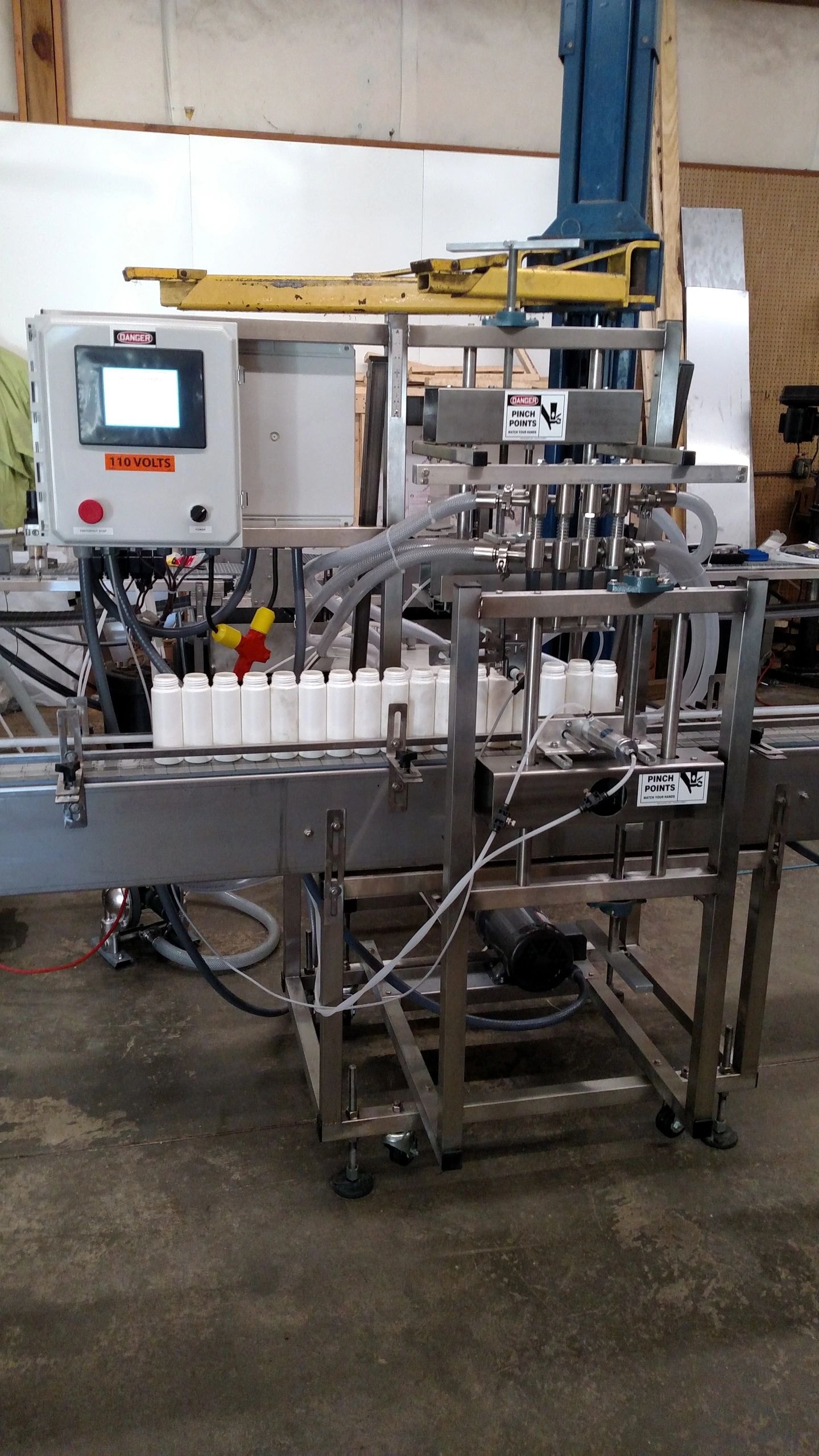 Four-head sanitary overflow filling machine for pharmaceutical products