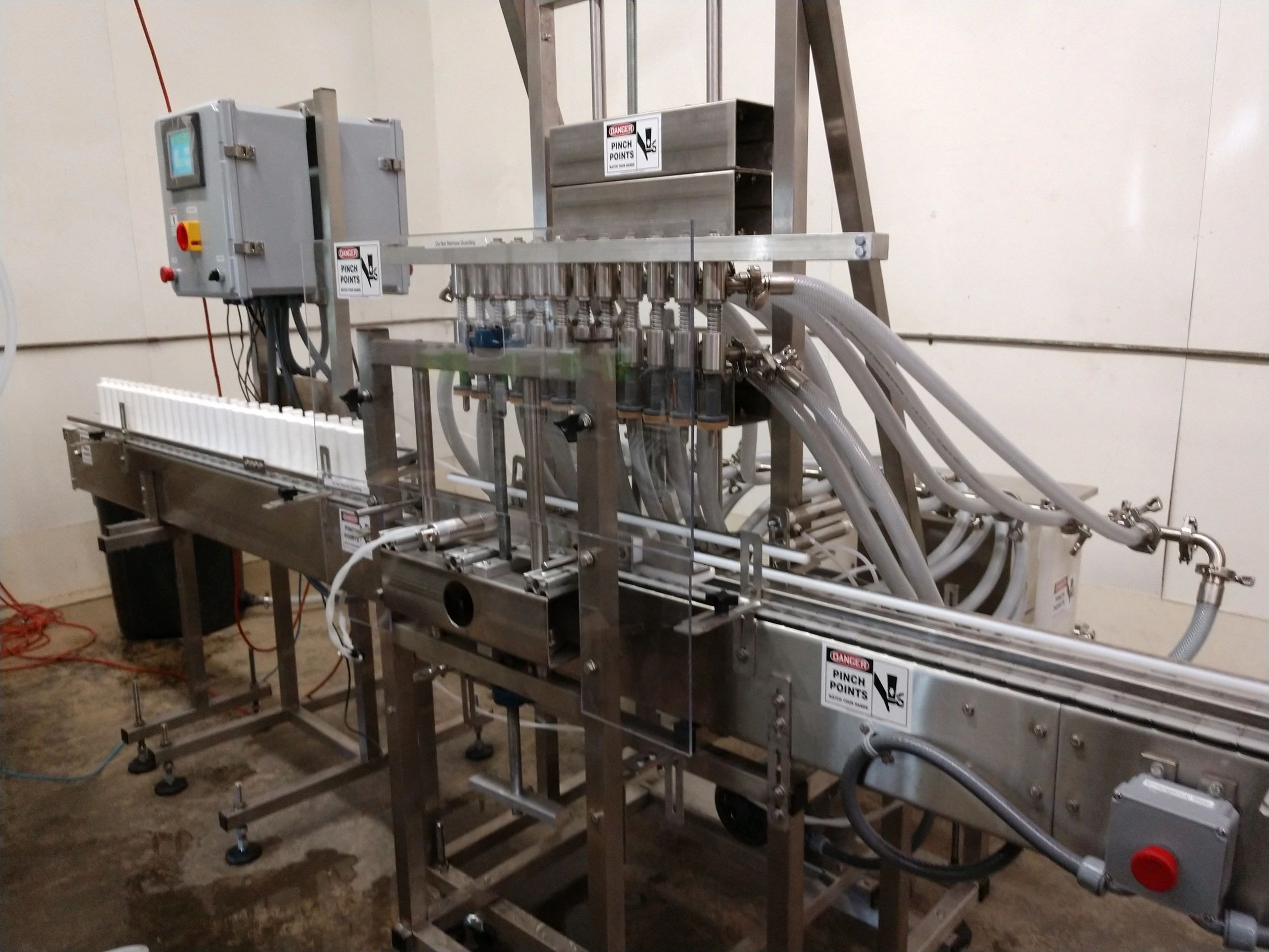Twelve-head automatic sanitary overflow filling machine on conveyor